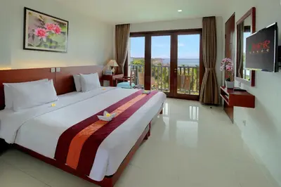 a hotel room with a large bed and a balcony at Bali Relaxing Resort and Spa in Nusa Dua