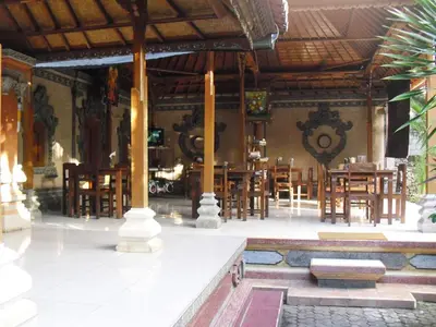 a dining room with wooden tables and chairs at Adus Beach Inn in Legian