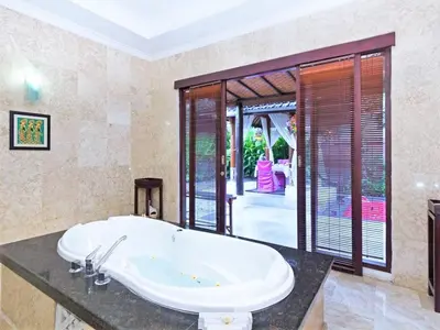 a bathroom with a large tub in a room at Lavender Villa & Spa in Kuta