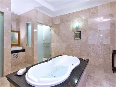 a large bathroom with a tub and a sink at Lavender Villa & Spa in Kuta