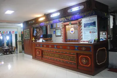 a restaurant with a large wooden counter in a building at Hotel Sorga Cottages in Kuta