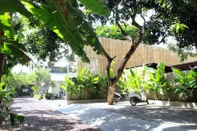 a courtyard with a tree and a fence at Rusty Seminyak in Seminyak