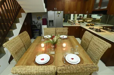 a wooden table in a kitchen with chairs at Villa Verde in Seminyak