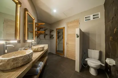 a bathroom with two sinks and a toilet at Luxury Villas Merci Resort 3BR Seminyak #2 in Kuta