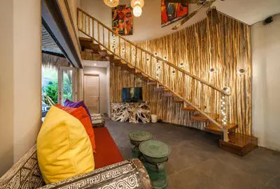 a living room with a couch and a staircase at Luxury Villas Merci Resort 3BR Seminyak #2 in Kuta