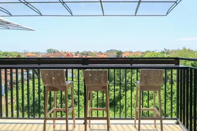 two chairs sitting on a balcony with a railing at Gelatik Bed And Breakfast in Seminyak