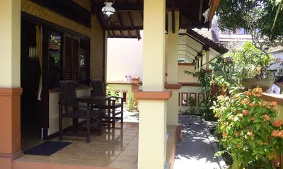 a porch of a house with a table and chairs at Bali Diva Hotel Kuta in Kuta