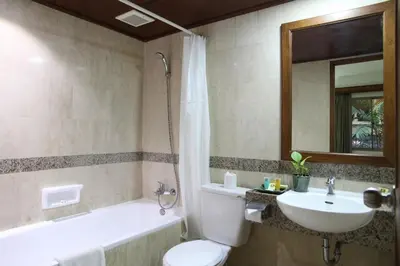 a bathroom with a toilet and a sink and a tub at The Jayakarta Bali Beach Resort in Legian