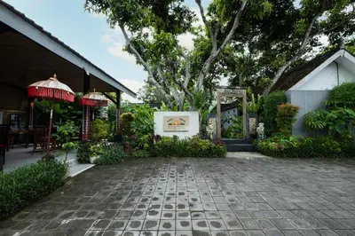 a courtyard with a tree and a building at Kubu Kak Dudung Villas in Jimbaran