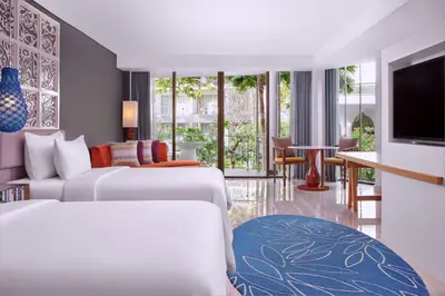 a hotel room with two beds and a television at Le Meridien Bali Jimbaran in Jimbaran