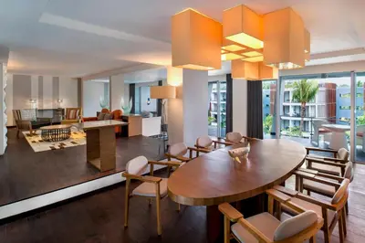 a dining room and living room with a table and chairs at Le Meridien Bali Jimbaran in Jimbaran