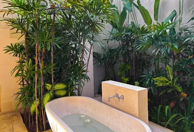 a bathroom with a bath tub next to plants at Nyaman Villas Seminyak in Seminyak