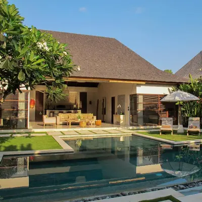 a house with a swimming pool in front of a house at Nyaman Villas Seminyak in Seminyak