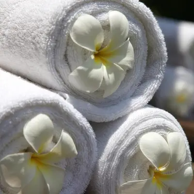 a group of towels with white flowers in them at Nyaman Villas Seminyak in Seminyak