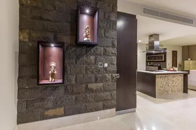 a stone wall in a kitchen with some pictures on it at Villa Deh Simba at Ayana With Private Pool in Jimbaran