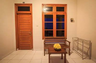a bench with flowers sitting in front of a door at Pondok Anyar Hotel in Kuta