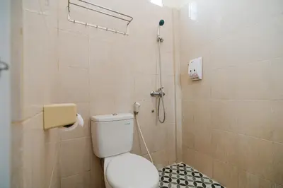 a bathroom with a toilet and a shower at Pondok Anyar Hotel in Kuta