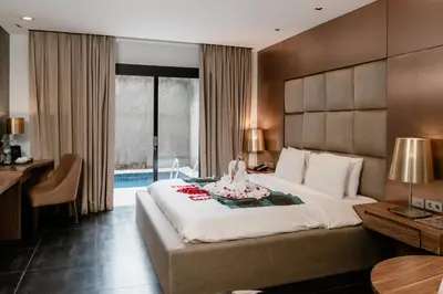 a bedroom with a large bed and a desk at Amaroossa Suite Bali in Nusa Dua