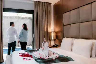 a man and a woman standing next to a bed at Amaroossa Suite Bali in Nusa Dua