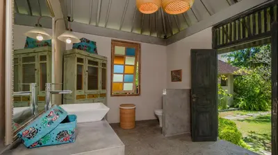 a bathroom with a tub and a sink and a mirror at Villa Koyama by Villa Finder in Seminyak