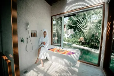 a woman sitting in a bath tub in a bathroom at Luxury Villa Seminyak near beach and Potato Head in Seminyak