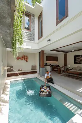 a man is in a swimming pool in a house at tanadewa Villas Nusa Dua Bali by Cross Collection in Nusa Dua
