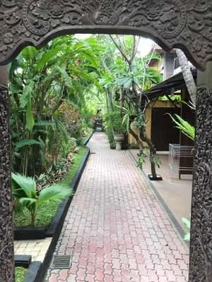an archway in a garden with plants and a sidewalk at De Puspa Residence Seminyak in Seminyak