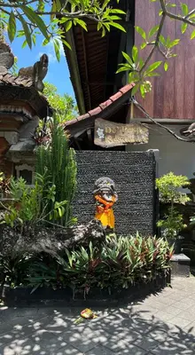 a statue of a bird sitting in some plants at De Puspa Residence Seminyak in Seminyak