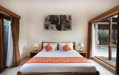 a bedroom with a large bed with orange pillows at Sandi Agung Villa in Seminyak