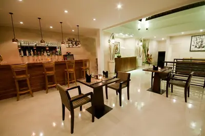 a restaurant with tables and chairs and a bar at Sandi Agung Villa in Seminyak