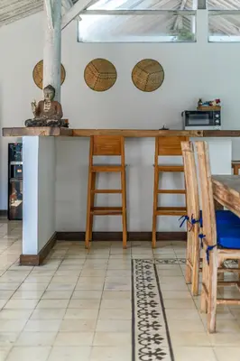 a kitchen with a counter and a table and chairs at Villa Laksmana Hideaway 2 - Surrounded by water- 2bd villa with fantastic pool! in Seminyak