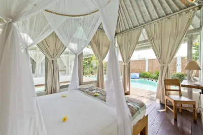 a bedroom with a canopy bed and a pool at Villa Laksmana Hideaway 2 - Surrounded by water- 2bd villa with fantastic pool! in Seminyak