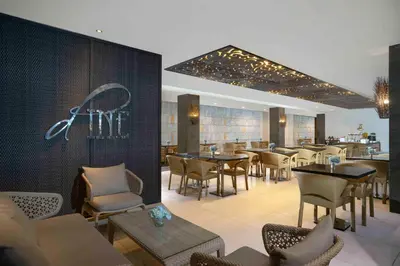 a restaurant with tables and chairs and a bar at Solaris Hotel Kuta in Kuta