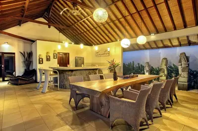 a dining room with a large wooden table and chairs at Villa Esperanto Seminyak in Seminyak
