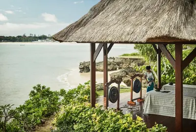 a person standing in front of a resort with the ocean at Four Seasons Resort Bali at Jimbaran Bay in Jimbaran