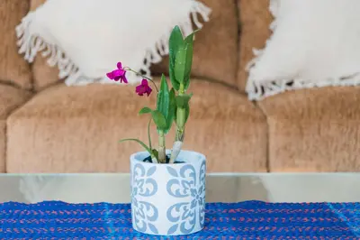 a blue and white vase with a flower on a table at VILLA DUNA Seminyak Bali in Seminyak