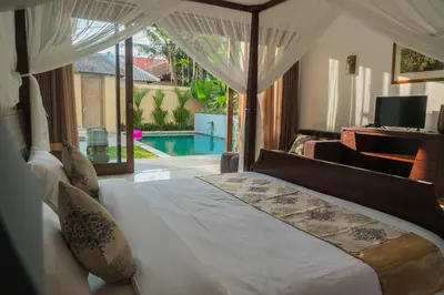 a bedroom with a bed with a view of a pool at VILLA DUNA Seminyak Bali in Seminyak