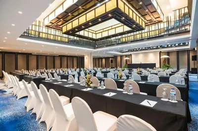 a large room with rows of tables and white chairs at Bali Dynasty Resort in Kuta