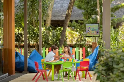 a man and woman sitting at a table playing with blocks at Padma Resort Legian in Legian
