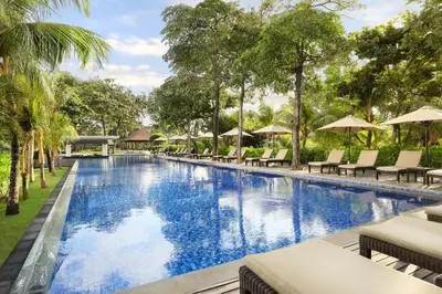 an infinity pool with chairs and umbrellas at a resort at Padma Resort Legian in Legian