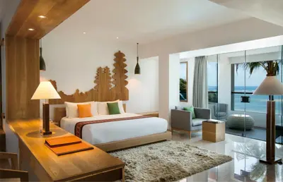 a bedroom with a bed and a living room at Hotel Nikko Bali Benoa Beach in Nusa Dua