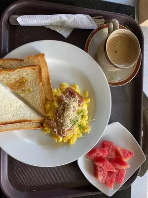 a tray with a plate of breakfast food with toast and watermelon at Dream @ Jimbaran in Jimbaran