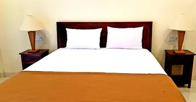 a bedroom with a large bed with two night stands at Eddys Cottages & Villa in Legian
