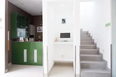 a staircase in a room with a green and white wall at Ara Inn Bed And Breakfast by ecommerceloka in Kuta