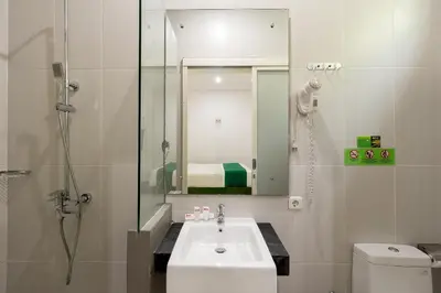 a bathroom with a sink and a shower and a toilet at Ara Inn Bed And Breakfast by ecommerceloka in Kuta