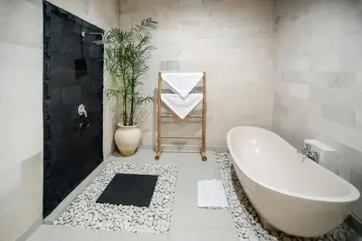 a white bathroom with a tub and a plant at Sandi Agung Villa Bidadari in Seminyak