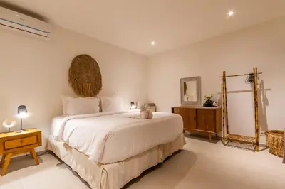 a bedroom with a large white bed and a mirror at Villa Namu by Alfred in Bali in Seminyak