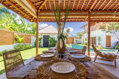 an outdoor dining table with chairs and a wooden table at Villa Namu by Alfred in Bali in Seminyak
