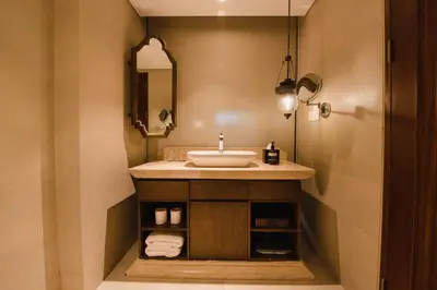 a bathroom with a sink and a mirror at Ramayana Suites and Resort in Kuta