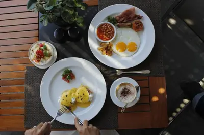 a table with three plates of breakfast food on it at The Kayana in Seminyak